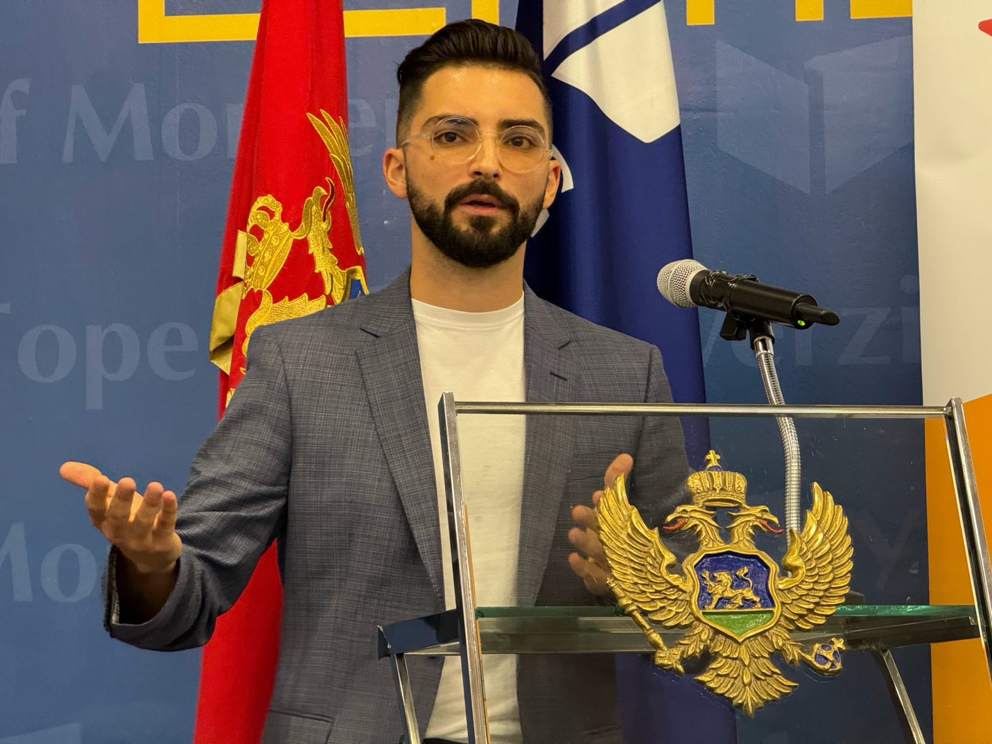 Branko Džakula speaking at a lectern at the University of Montenegro about a career in cybersecurity.